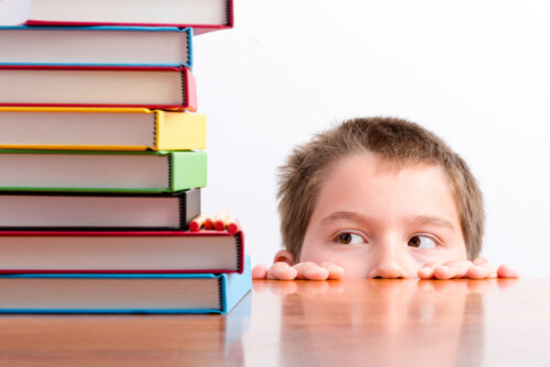 Criança assustada olhando para uma pilha de livros.