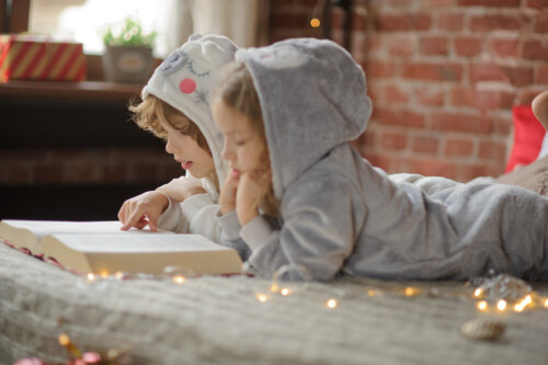 Niños leyendo Enigmas de historia con el pijama puesto.