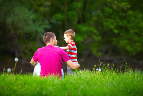 Padre hablando con su hijo en el campo para potenciar su flexibilidad psicológica.