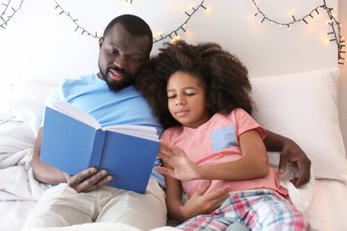 Padre leyendo un cuento a su hija antes de dormir.
