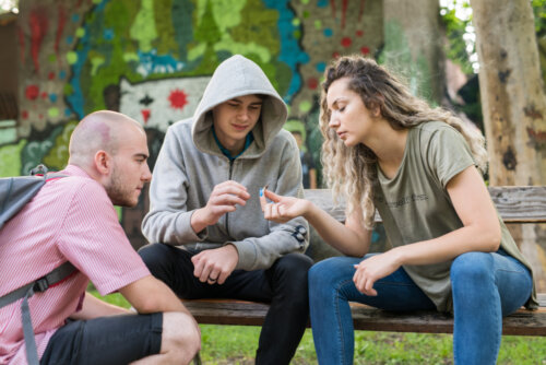 Grupo de adolescentes consumiendo drogas en el parque sin tener en cuenta cómo la droga afecta al desarrollo cognitivo.