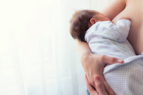 Bebé mamando del pecho de su madre durante la lactancia.
