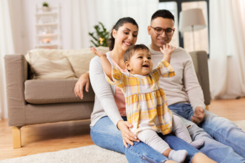 Familia con su bebé de visita en casa de unos amigos.