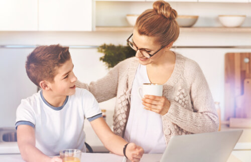 Mère parlant à son fils adolescent autour d'un café à la main.