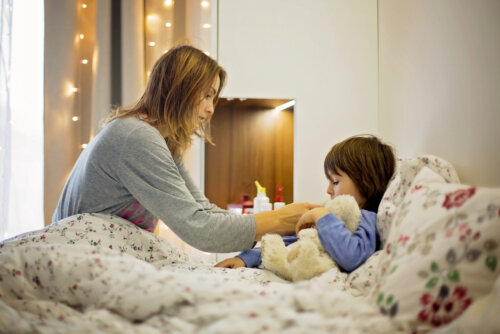 Madre con su hijo en la cama enfermo con alguna de las infecciones bacterianas o virales.