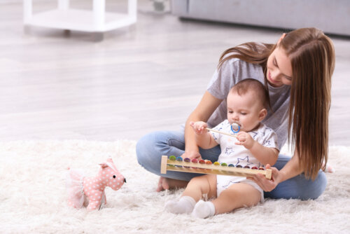 Mamá jugando con su bebé y haciendo ejercicios para su desarrollo.