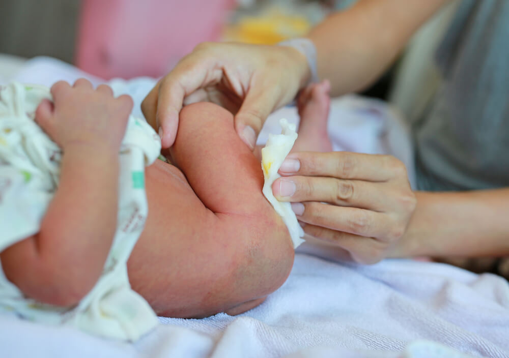 Un adulte qui change la couche d'un bébé.