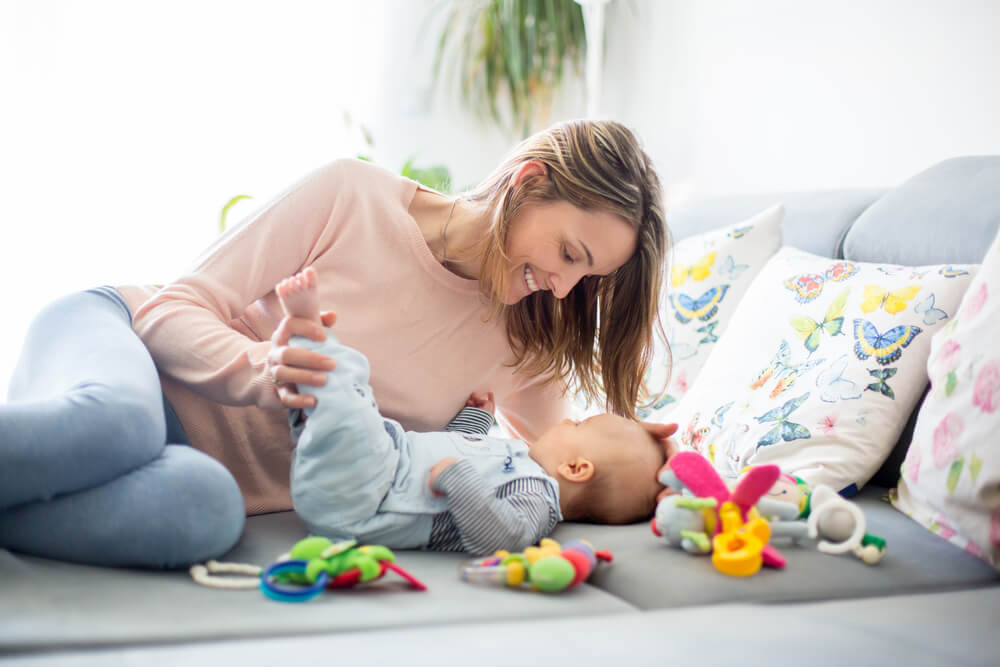 Madre jugando con su bebé para estimularlo.