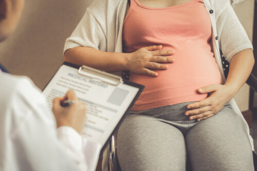 Mujer en la consulta del médico preguntando por un tratamiento dietético para las rampas en el embarazo.