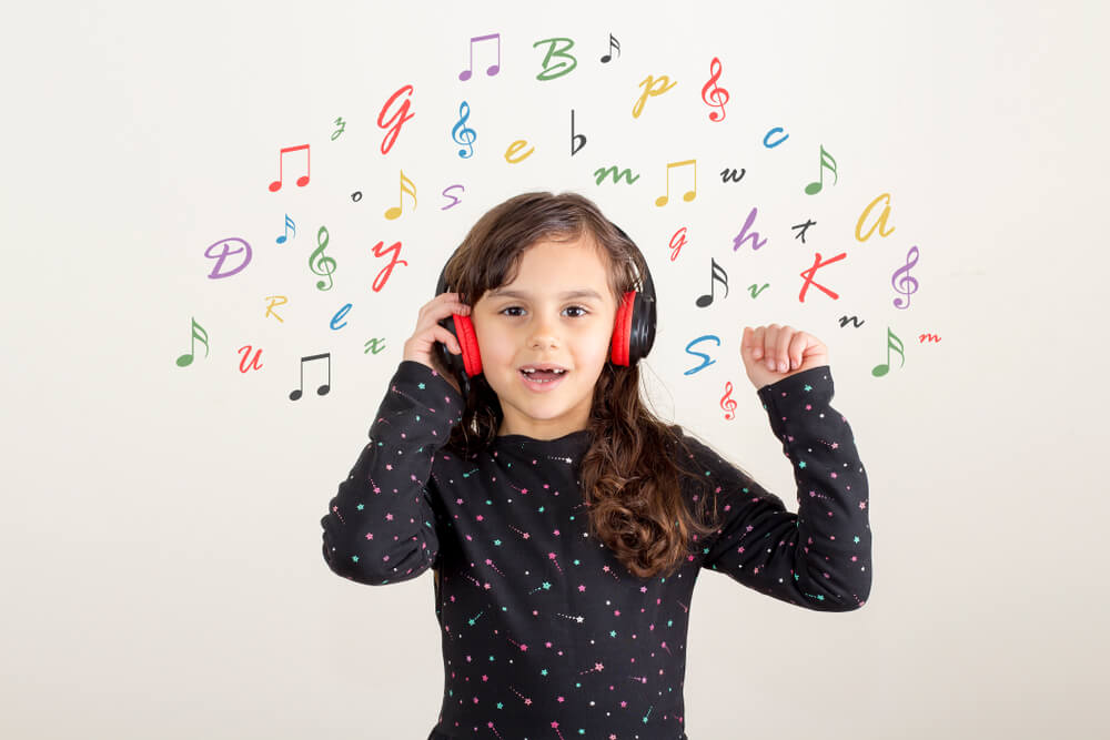 Petite fille écoutant des chansons pour enfants en anglais pour apprendre la langue.