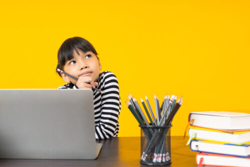 Niña estudiando frente al ordenador.