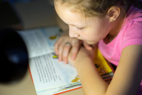 Une jeune fille qui regarde un livre;