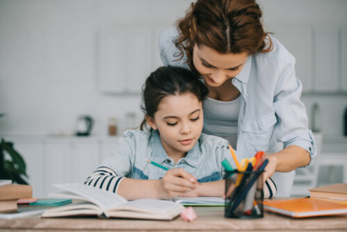 Niña haciendo ejercicios de hiatos y diptongos con la ayuda de su madre.