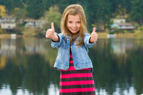 Niña con los pulgares arriba mostrando una enorme positividad.