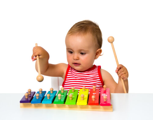 Niña tocando el xilófono porque la música es beneficiosa para el desarrollo cognitivo infantil.