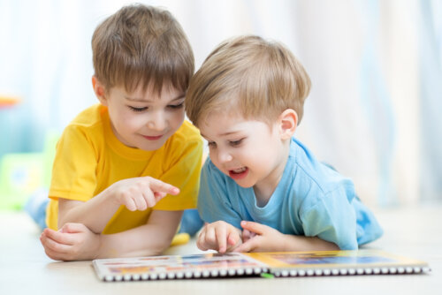 Deux enfants qui regardent un livre.