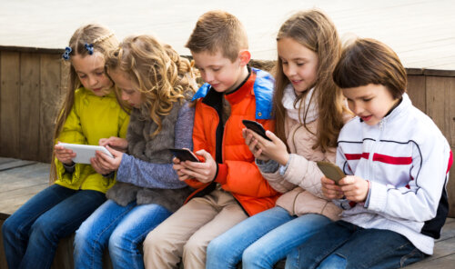 Niños mirando sus redes sociales en el móvil.