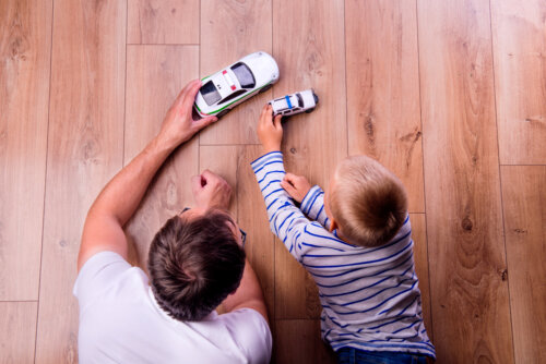 Padre e hijo jugando a los coches juntos.