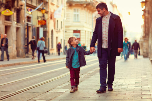 Padre paseando con su hijo por la ciudad aprendiendo a ser un padre tranquilo.