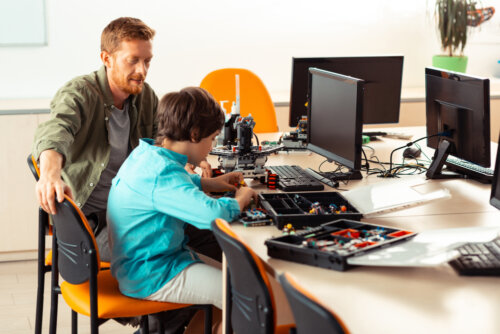 Profesor con su alumno promoviendo una educación STEM en clase de tecnología.