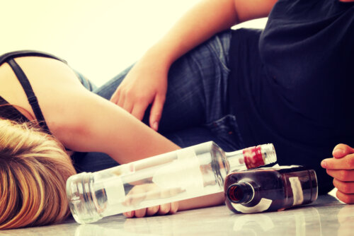 Adolescentes tumbados en el suelo borrachos después de beber alcohol.