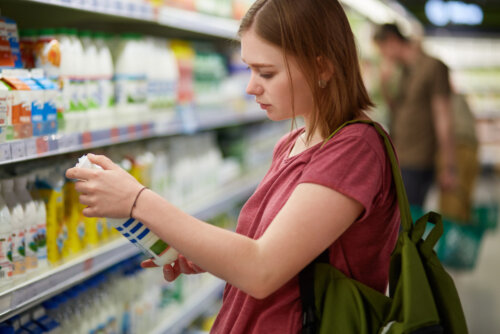 Chica adolescente analizando las etiquetas de los alimentos que compra debido a que padece ortorexia, es decir, obsesión por la comida sana.
