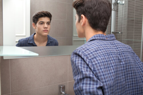 Chico adolescente mirándose al espejo.