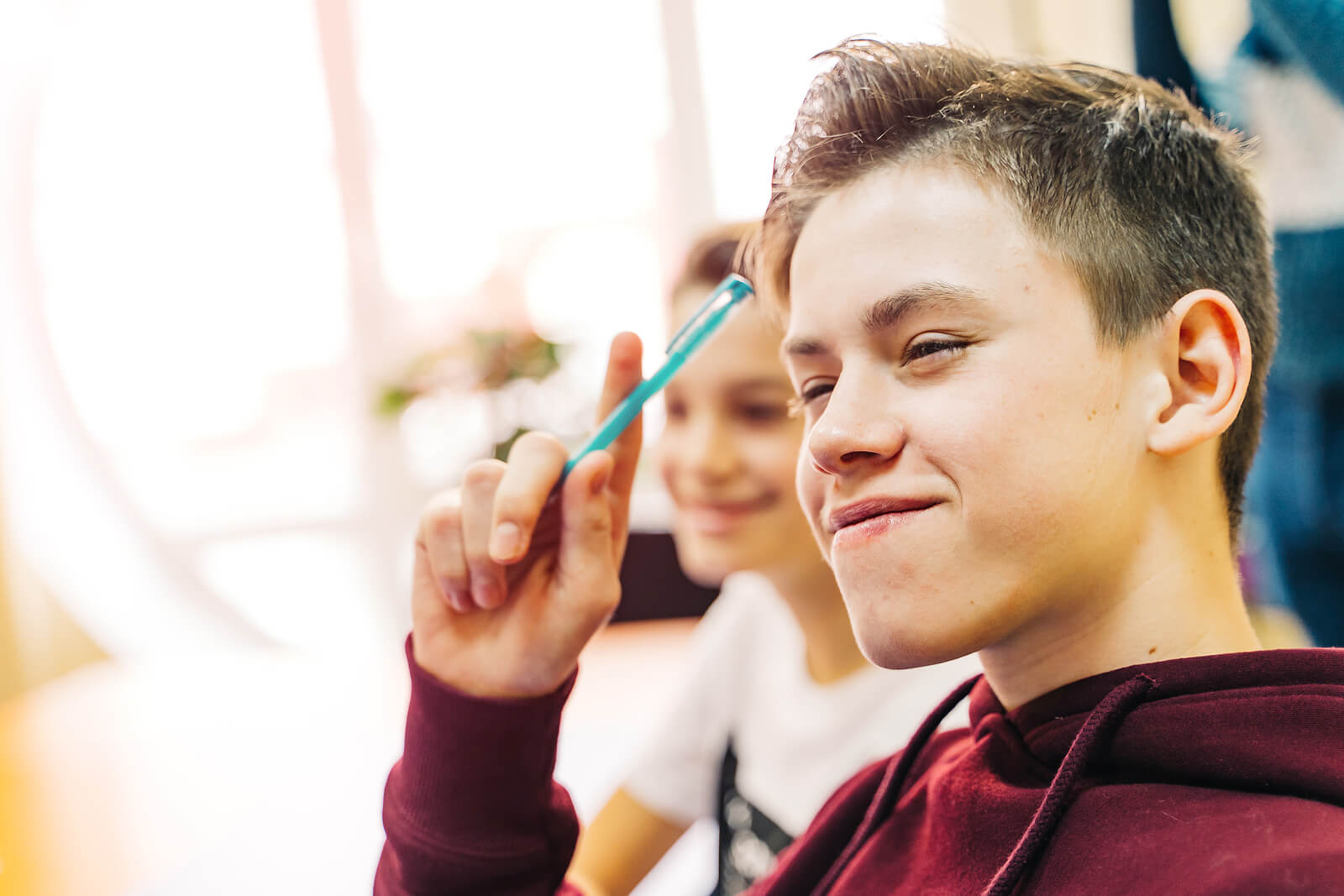 Chico adolescente aprendiendo a tomar buenos apuntes en clase.