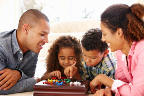 Familia jugando a juegos de mesa para prevenir la adicción a los videojuegos.