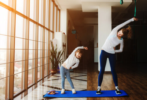 Madre e hija haciendo ejercicio en casa para sobrellevar la cuarentena.