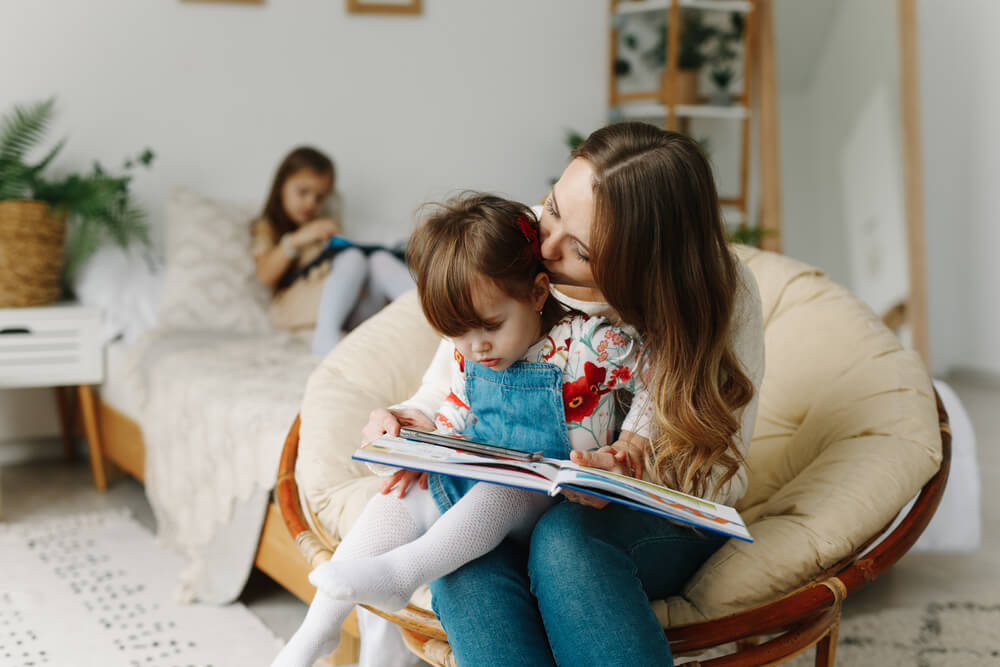 Madre e hijas leyendo libros y cuentos.