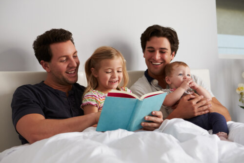 Padres leyendo un cuento a sus hijos en la cama por el Día del Padre.