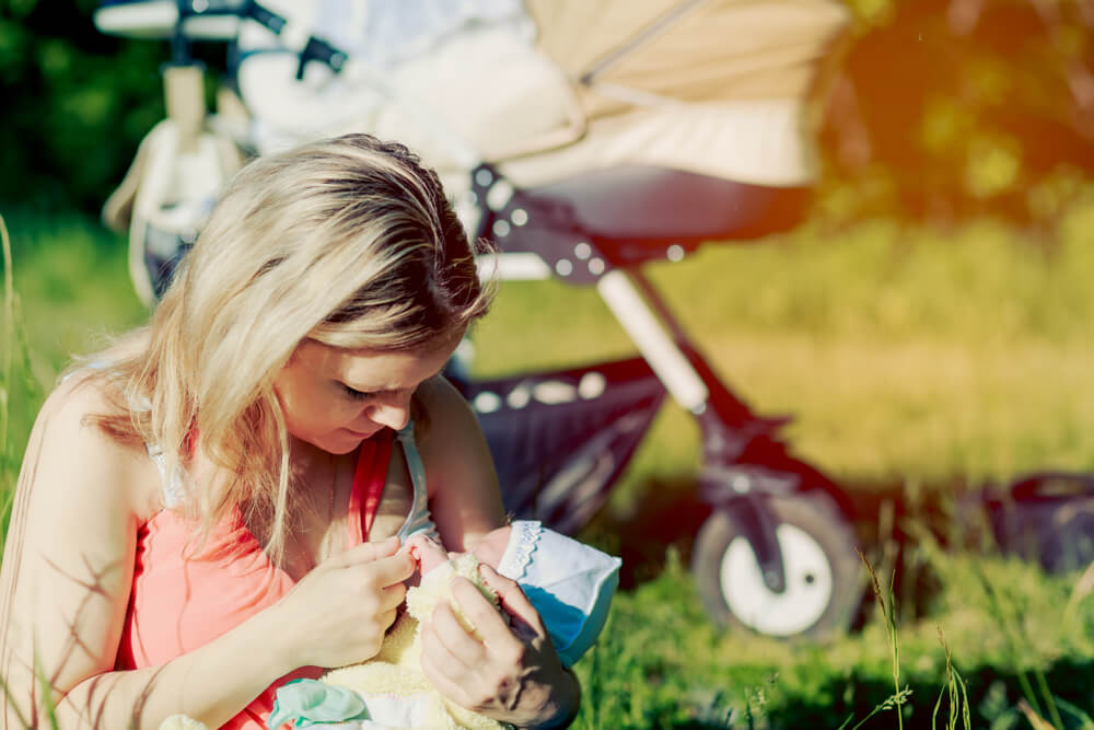 Femme allaitant son bébé dans le parc.