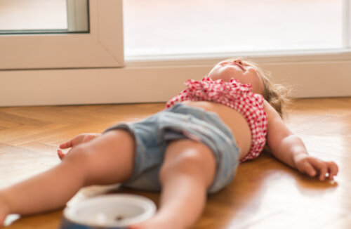 Niña en plena adolescencia infantil tumbada en el suelo enfadada.