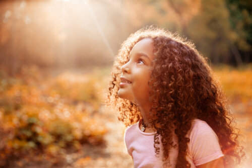 Niña mirando un rayo de sol.