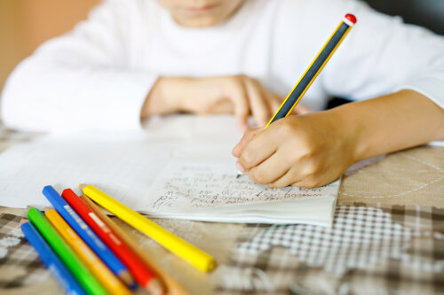 Niño escribiendo una carta a mano.