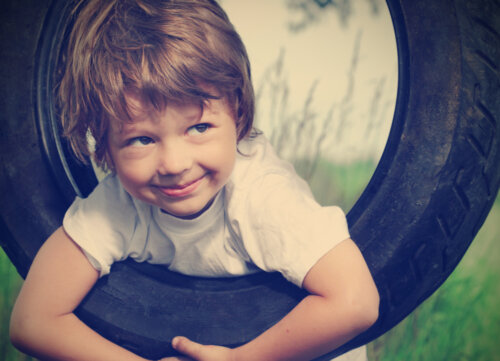 Niño feliz en un columpio al aire libre.