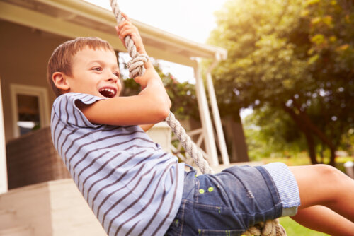 Niño feliz jugando al aire libre trabajando el merecimiento.