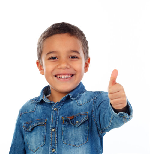 Niño con el pulgar arriba, ejemplo de positividad gracias a su amor propio.