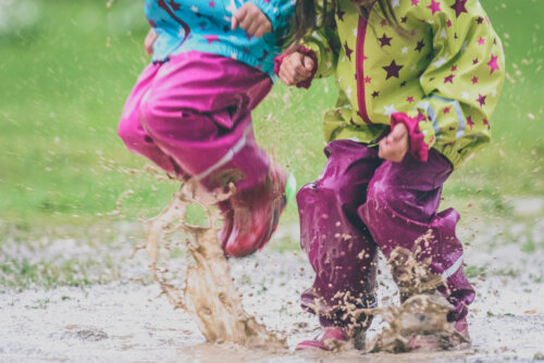 Niños jugando en el barro y manchándose.