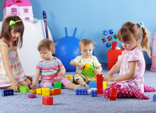 Bebés jugando con bloques para trabajar la motricidad.