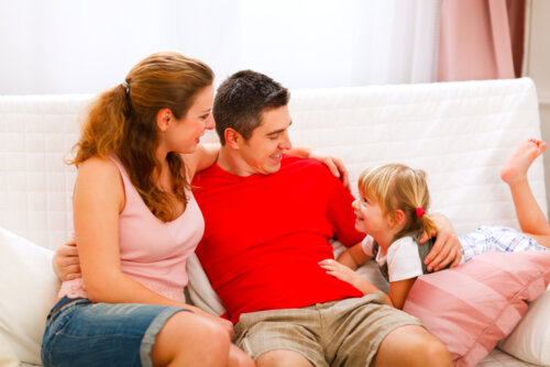 Padres hablando con su hija en el sofá sobre afrontar las adversidades.