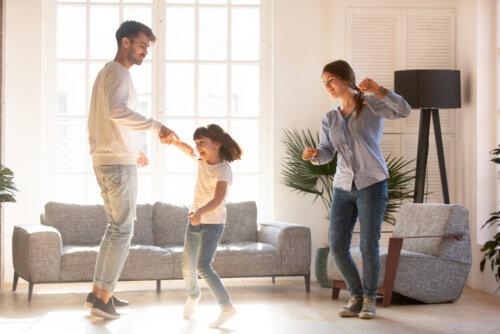 Familia bailando en el salón de casa.