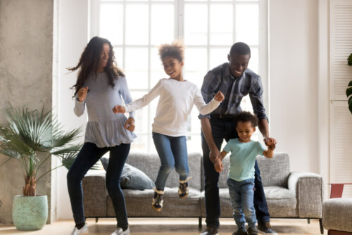 Padres haciendo felices a sus hijos bailando con ellos.