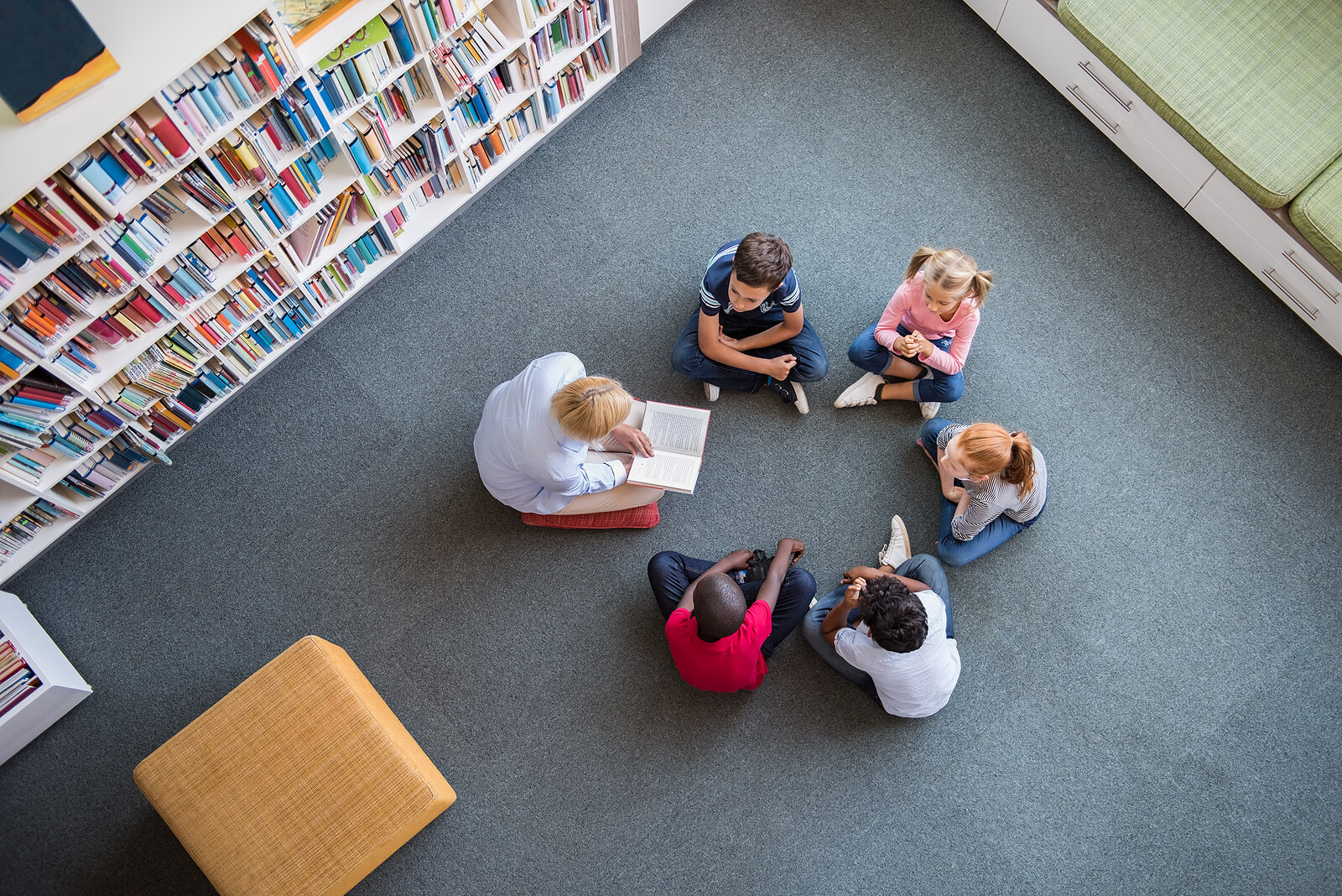 Profesor con sus alumnos en clase llevando a cabo actividades para bibliotecas de aula.