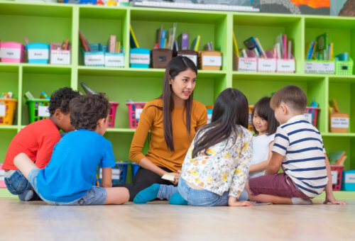 Profesora con sus alumnos haciendo actividades en la biblioteca de aula.