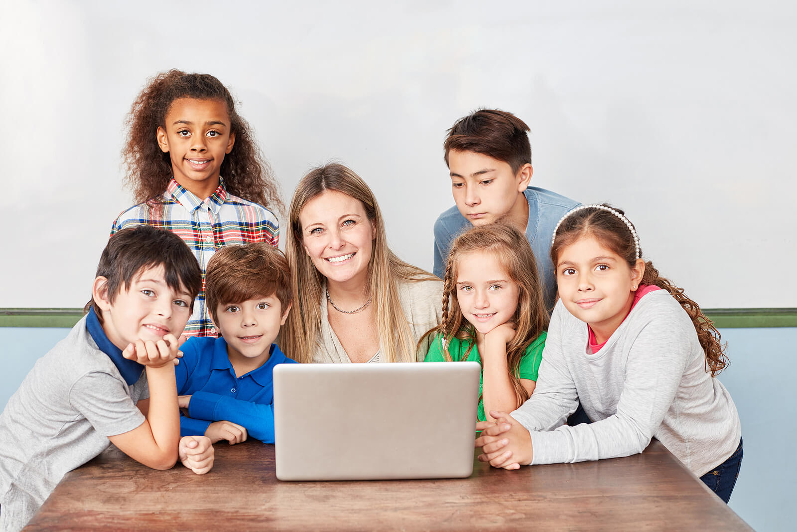 Maestra feliz con sus alumnos en clase.
