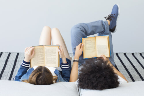 Jóvenes adolescentes leyendo libros tumbados en la cama.