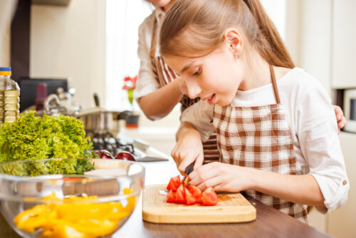 Chica adolescente cocinando con su madre.