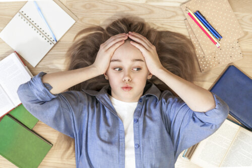 Chica adolescente con problemas de aprendizaje rodeada de libros.